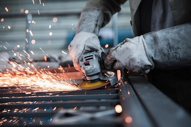 Técnico utilizando una herramienta de corte para fabricar estructuras metálicas con precisión.